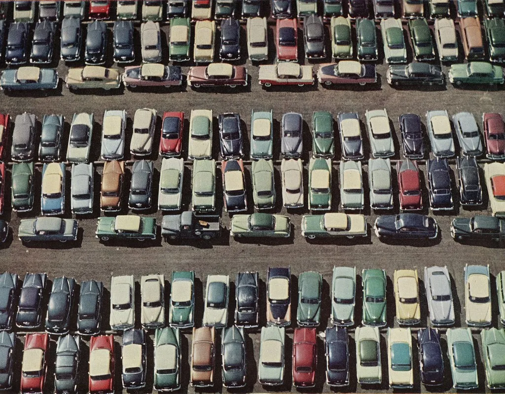 Rows of cars filling a dealership lot, seen from above