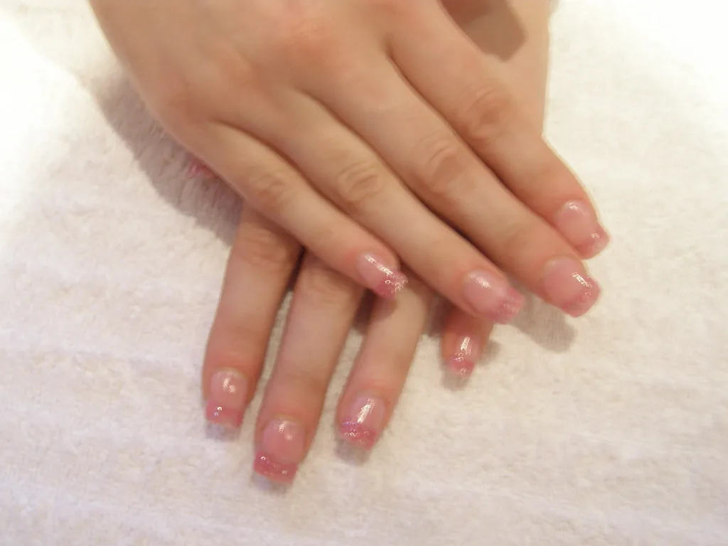 Freshly manicured nails resting on a salon towel