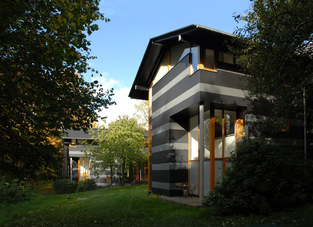 A residential property set back from a tree-lined path