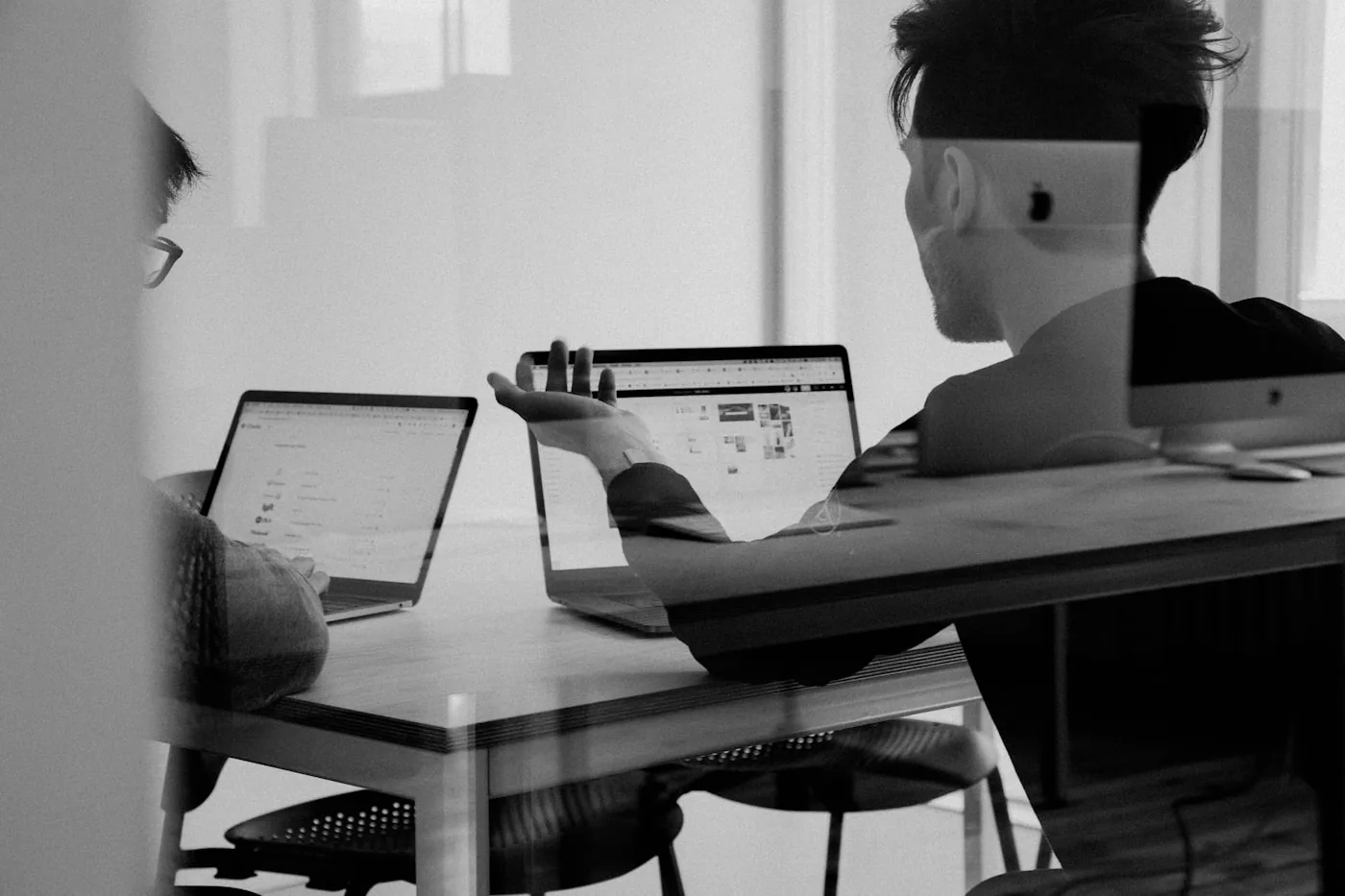 Two support team members working together at a desk in an office